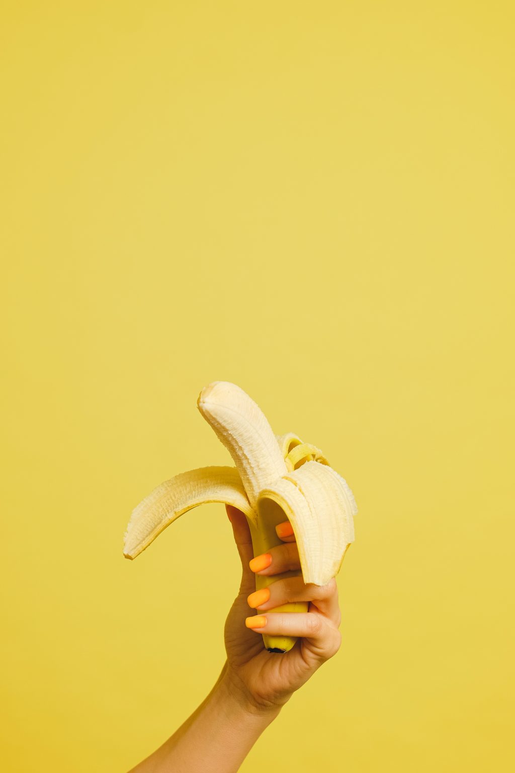 Over Mondial Food Solutions: gepelde banaan in hand op gele achtergrond